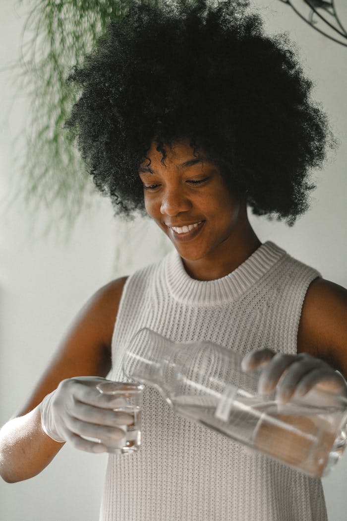 Black woman preparing liquid incense for aromatherapy in workshop